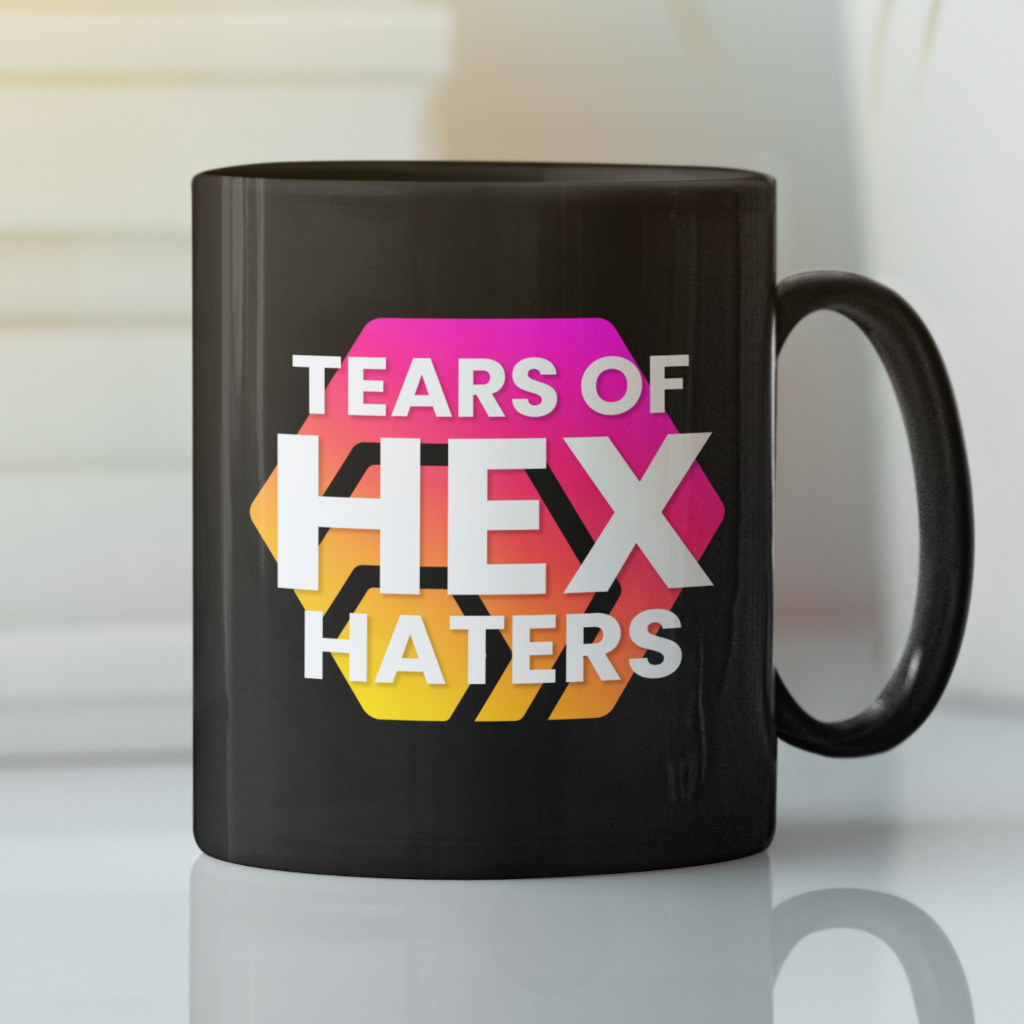 A black mug featuring Hex logo &amp; &quot;Tears of Hex&quot; Haters is written on the front side of the mug, displayed on a white surface